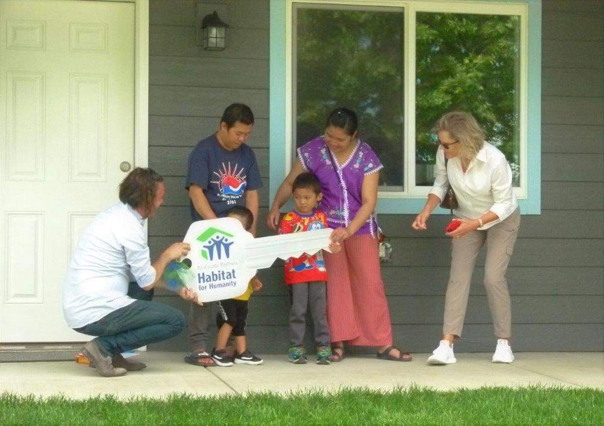 A family of four receives their keys at Habitat for Humanity’s 150th home dedication.