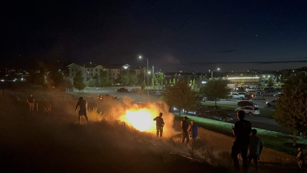 Police and bystanders reacted to a grass fire started by fireworks on the embankment of the Interstate 182 bridge at Columbia Point Marina Park in Richland on July 4.