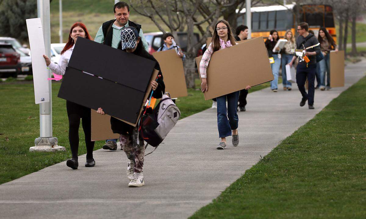 Students carry their project display boards across the WSU Tri-Cities campus Thursday morning in Richland to the 71st annual Mid-Columbia Regional Science & Engineering Fair.