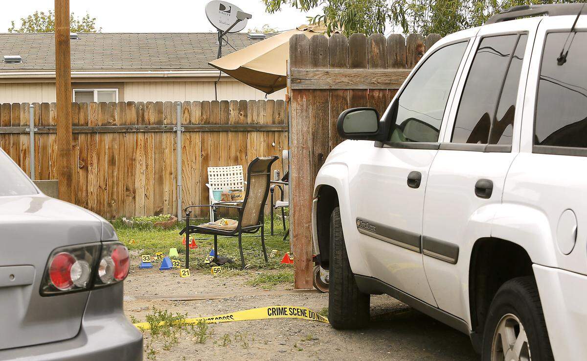 Several dozen crime scene markers are visible through an opening in the fence in the backyard of a house at 1901 E. Lewis St. where one man was fatally shot and two others wounded Wednesday night in Pasco. Watch a video at: tricityherald.com/videos