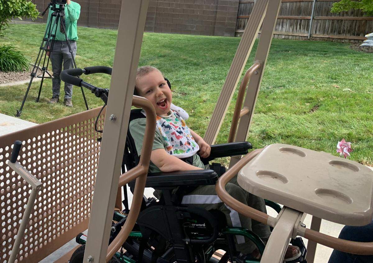 Kade Korstvedt smiles on the new swing for immobilized children.