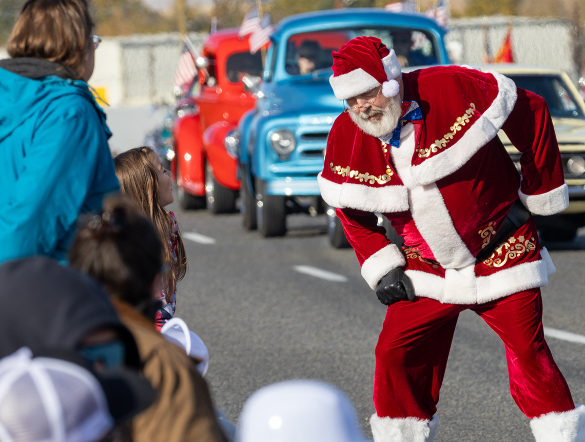 Santa Claus greets children along West Van Giesen Street as vintage vehicles follow during the 26th annual Tri-Cities Veterans Day Parade in West Richland, Wash., on Saturday, Nov. 8, 2025.