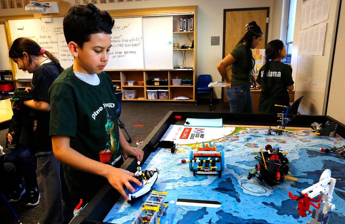 Fourth-grade student Sergio Preciado from Marcus Whitman Elementary School in Richland demonstrates how the Lego robot he helped write code for works.
