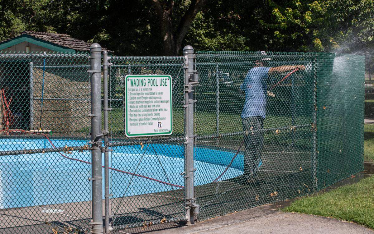 A City of Richland employee cleans the wading pool in anticipation for its opening in the coming days. Temperatures soared in Tri-Cities this week making outdoor manual labor especially dangerous.