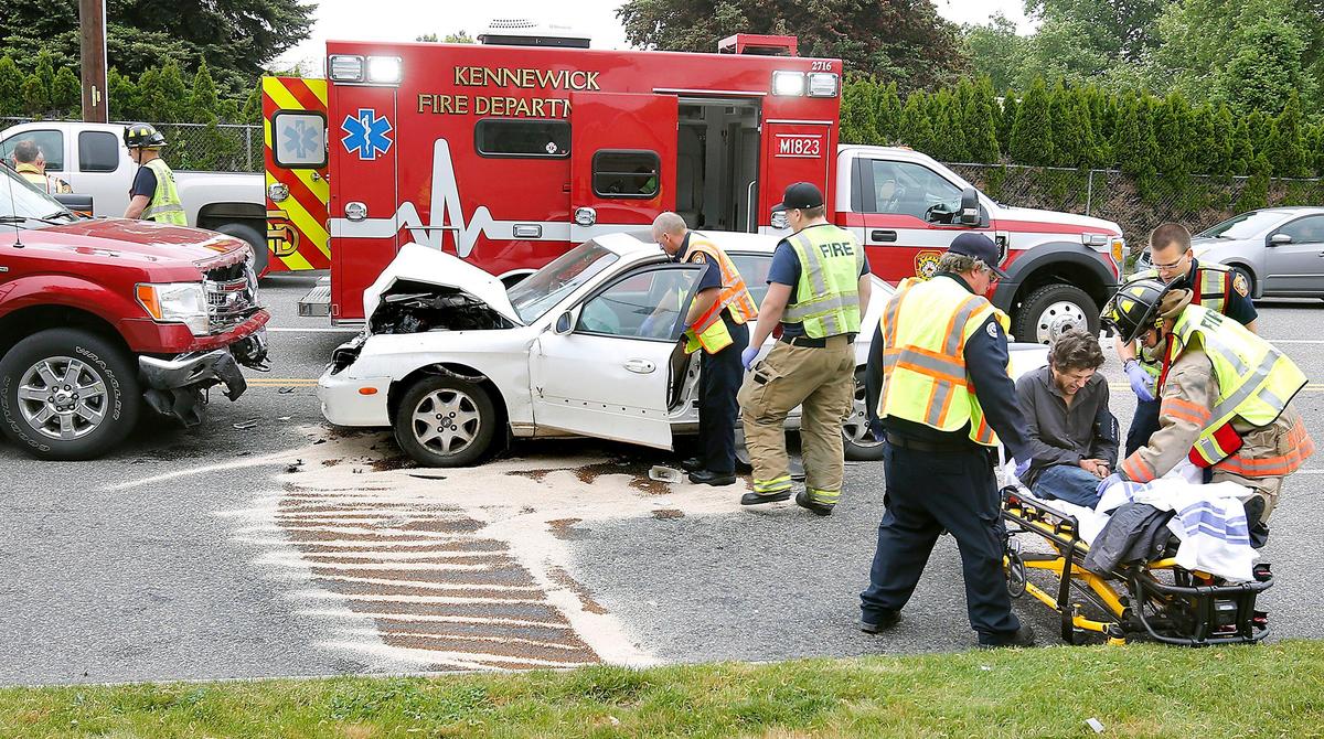 2019 file photo — A Tri-Cities man grimaces as Kennewick paramedics and firefighters prepare to move him to an ambulance following a two-vehicle head-on collision on West 10th Avenue near South Kellogg Street.