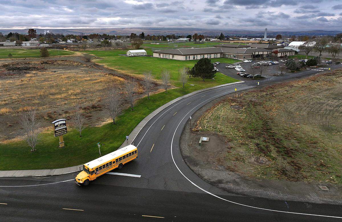 School bus turns off Maple Street onto Jantz Road after passing by Columbia High School, middle school and elementary in Burbank.