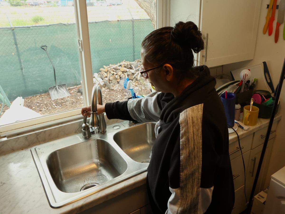Amber Waid turns on the water in the sink at her home at the Sands Mobile Home Park in Pasco where she says water pressure and flow are a big problem for many residents.