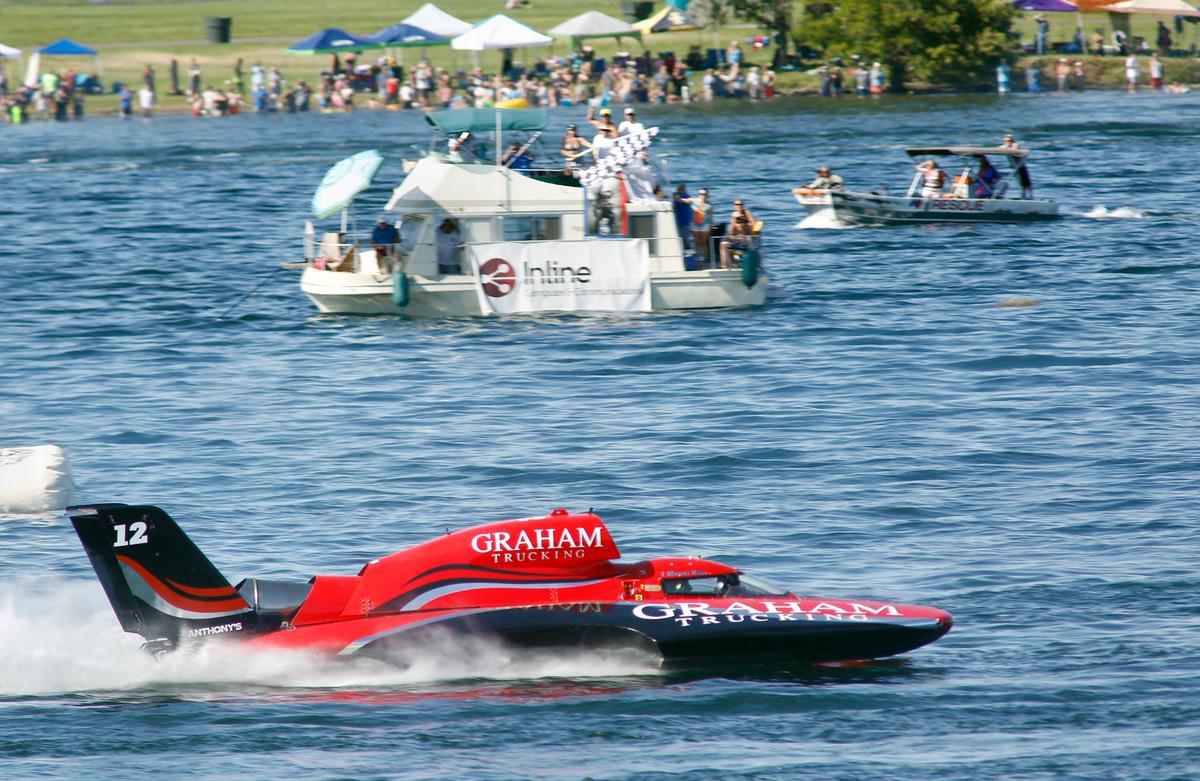 J. Michael Kellly takes the checker flag Sunday in the U-12 Graham Trucking unlimited hydroplane to claim the championship race in the HAPO Columbia Cup in Kennewick.