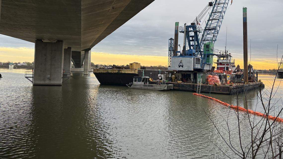 Why are a barge, crane and divers under the cable bridge in Tri-Cities?