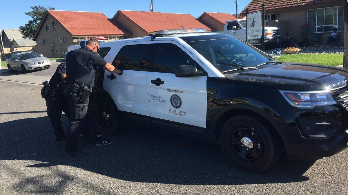 Kennewick police say a suspect who tried to enter an unlocked residence was arrested after jumping off a box truck and lunging at an officer.
