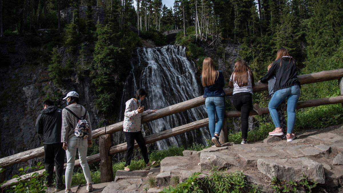 Visitors to Mount Rainier National Park view a waterfall during the summer season. Working outdoors is one of the best ways to spend the summer in the Pacific Northwest.