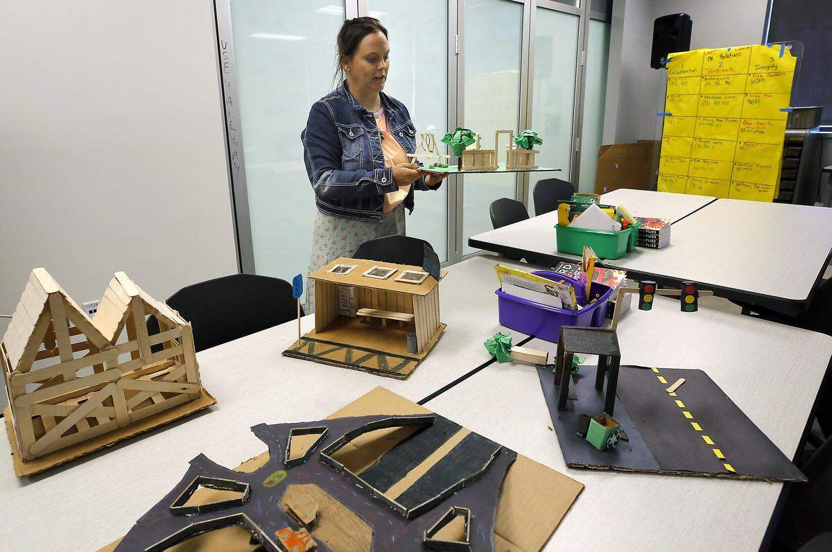 Orion High school teacher Rebecca Riley shows off some of the student-built displays that were part of their classroom projects that incorporated AI.