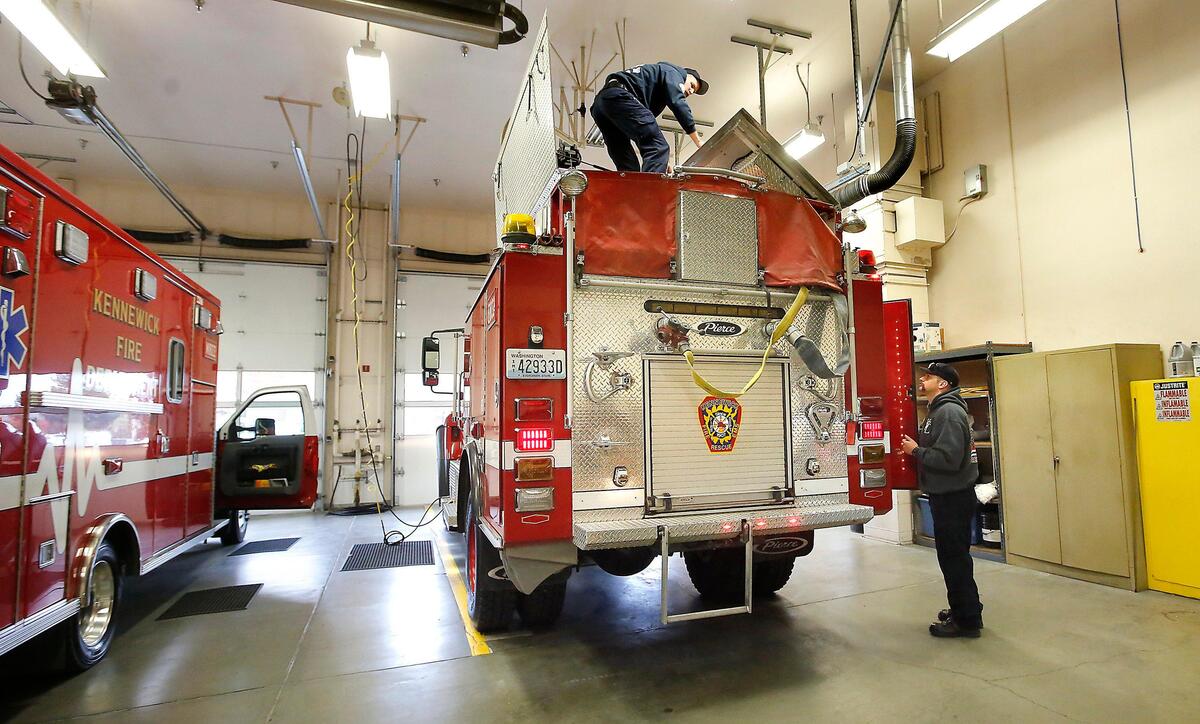 Kennewick firefighters Nathan Miller, left, and Matt Gau make final preparations Monday to the wildland fire truck they’re scheduled to take to Northern California. They are part of a mobilization of several strike teams from around the state, including Pasco, Benton County, Walla Walla County and Chelan County.