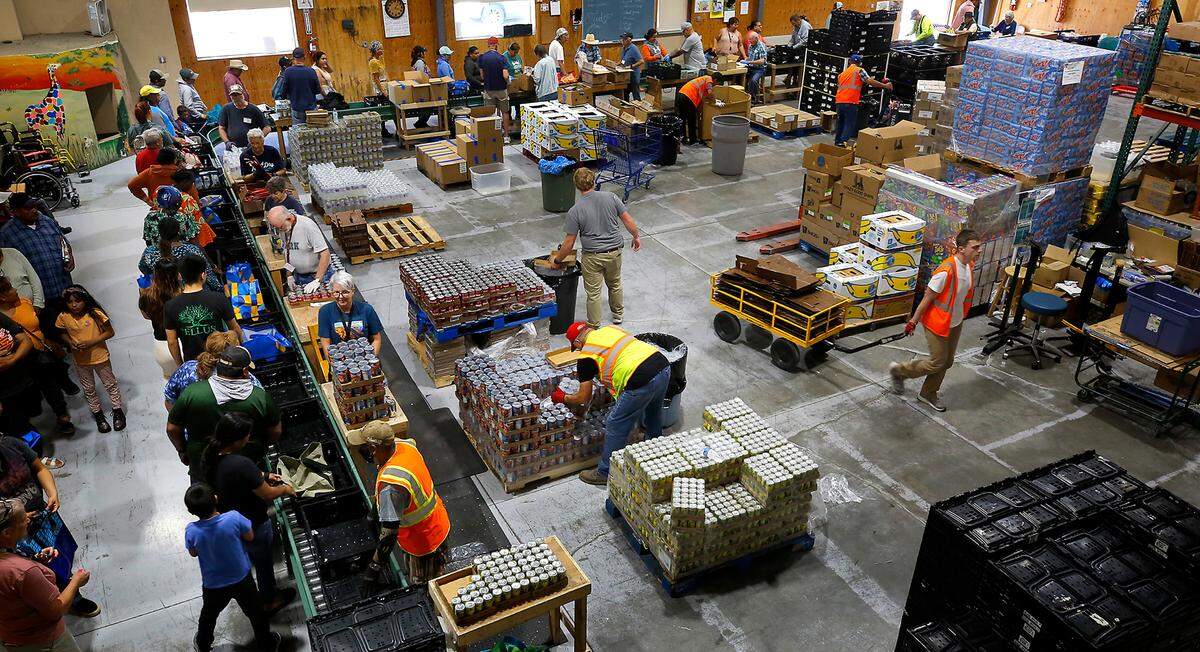 Volunteers distribute food at the St. Vincent de Paul Food Bank facility in Pasco. They’re distributing more than 100,000 pounds of food each week, despite only being open for a few hours on Wednesdays.