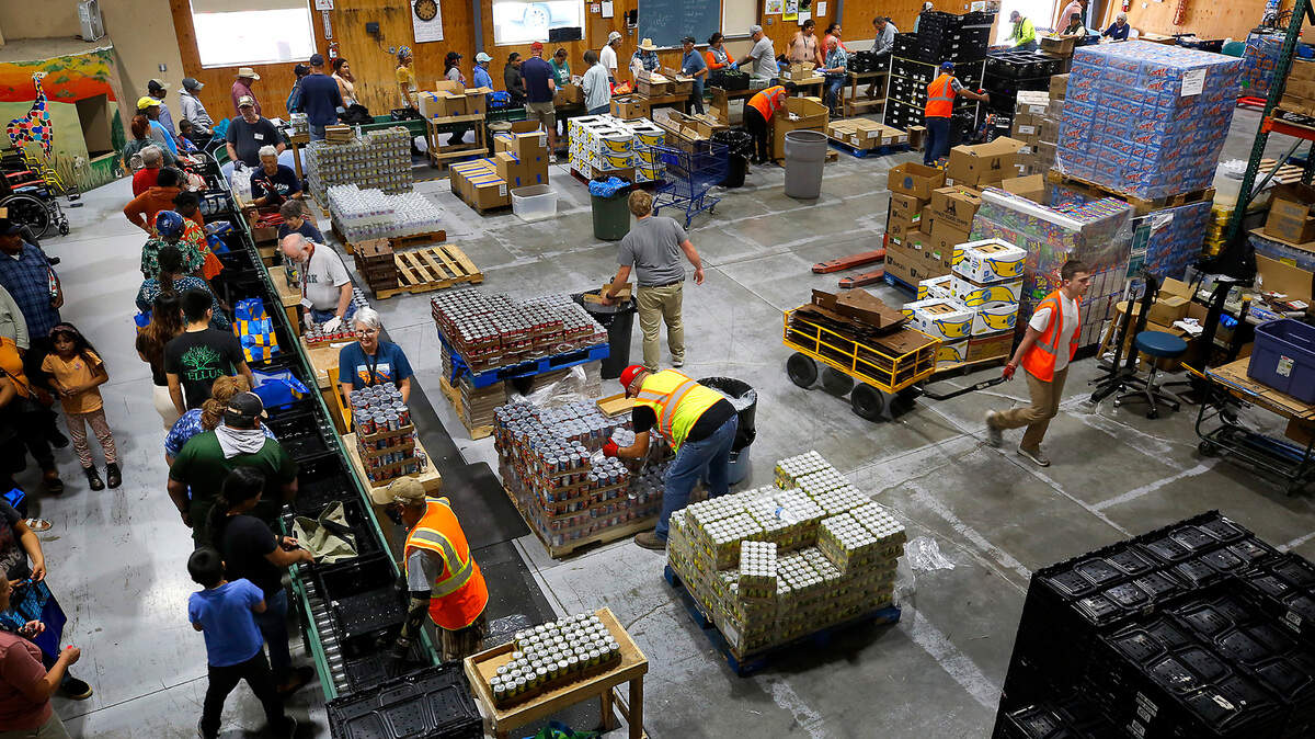 Volunteers distribute food at the St. Vincent de Paul Food Bank facility in Pasco. They’re distributing more than 100,000 pounds of food each week, despite only being open for a few hours on Wednesdays.