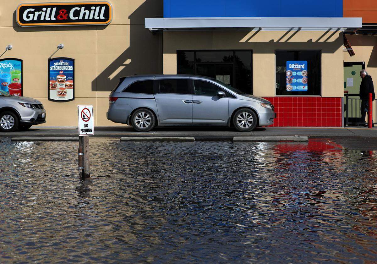 Customers wait in the drive-thru lane Thursday next to “Lake Dairy Queen” off Jadwin Avenue in Richland following a day of rainfall in the Tri-Cities. The infamous lake, complete with it’s own “No Fishing” sign forms in a depression in the parking lot between Dollar Tree and the drive-thru for the Dairy Queen at 1313 Jadwin Ave.