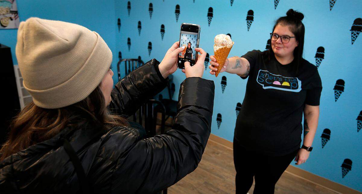Mallory Chapin, owner of What’s the Scoop?, poses for a photo likely to end up in a social media post about the new Kennewick ice cream store. Chapin’s cousin, Courtney Brady, is taking the photo.