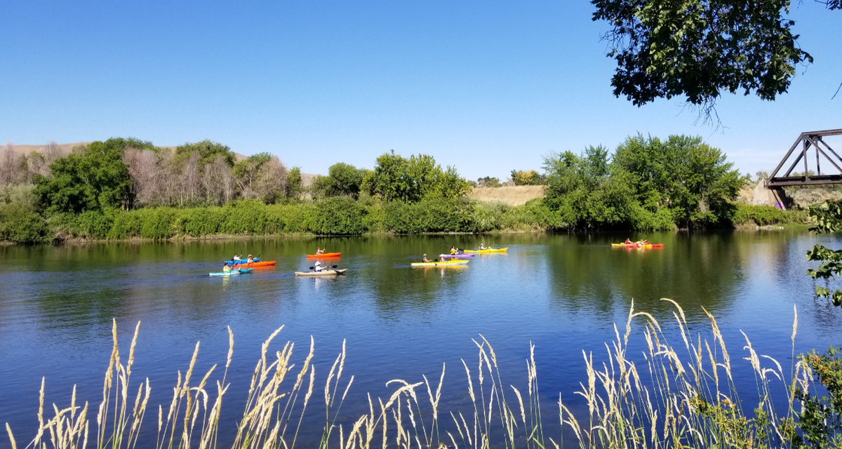 Kayakers pass the site of land that will be purchased for a park on the Yakima River in Benton City to provide access to the river.