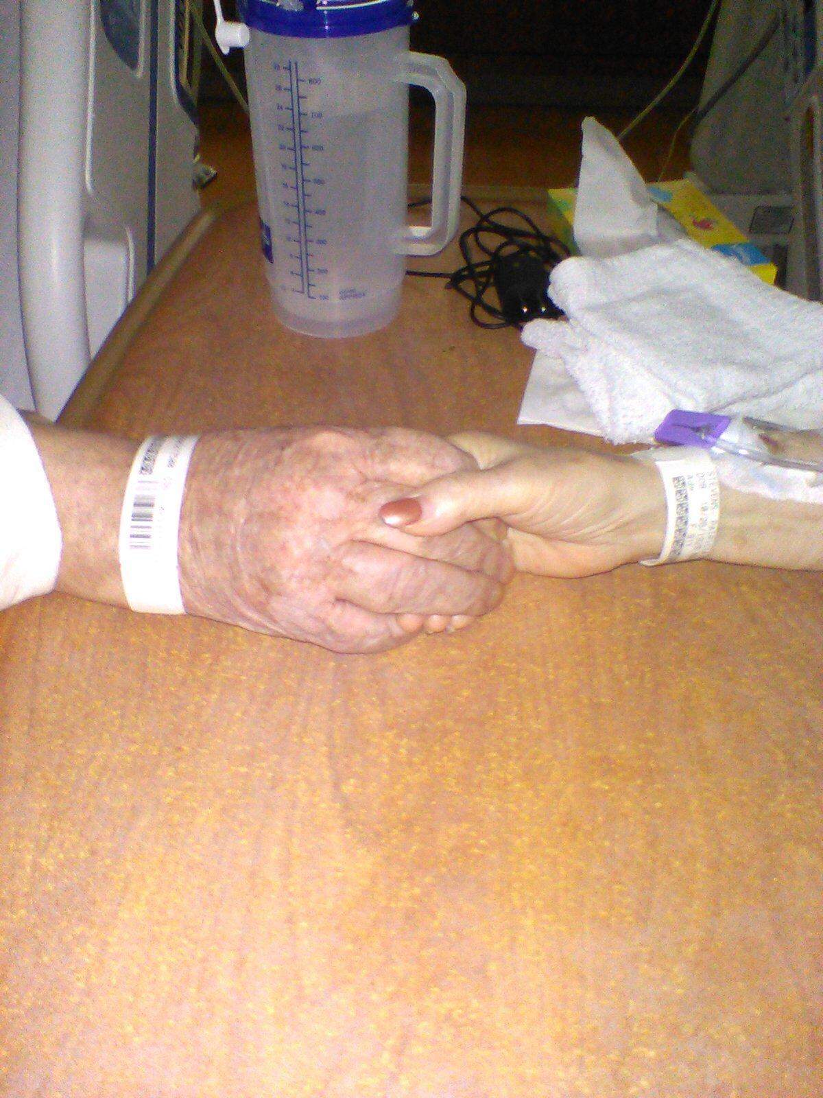 Homer and Patricia Stevens hold hands from their hospital beds after both were admitted to Kadlec Regional Medical Center in Richland with COVID-19. A nurse took this photo for their family.