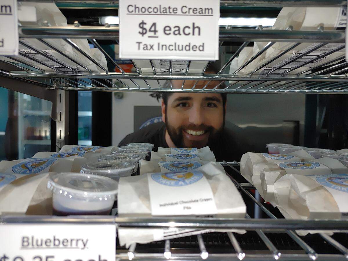 Justin Tjarks, owenr and baker for Pie Sharks at the Pasco Specialty Kitchen, peers through the display case.