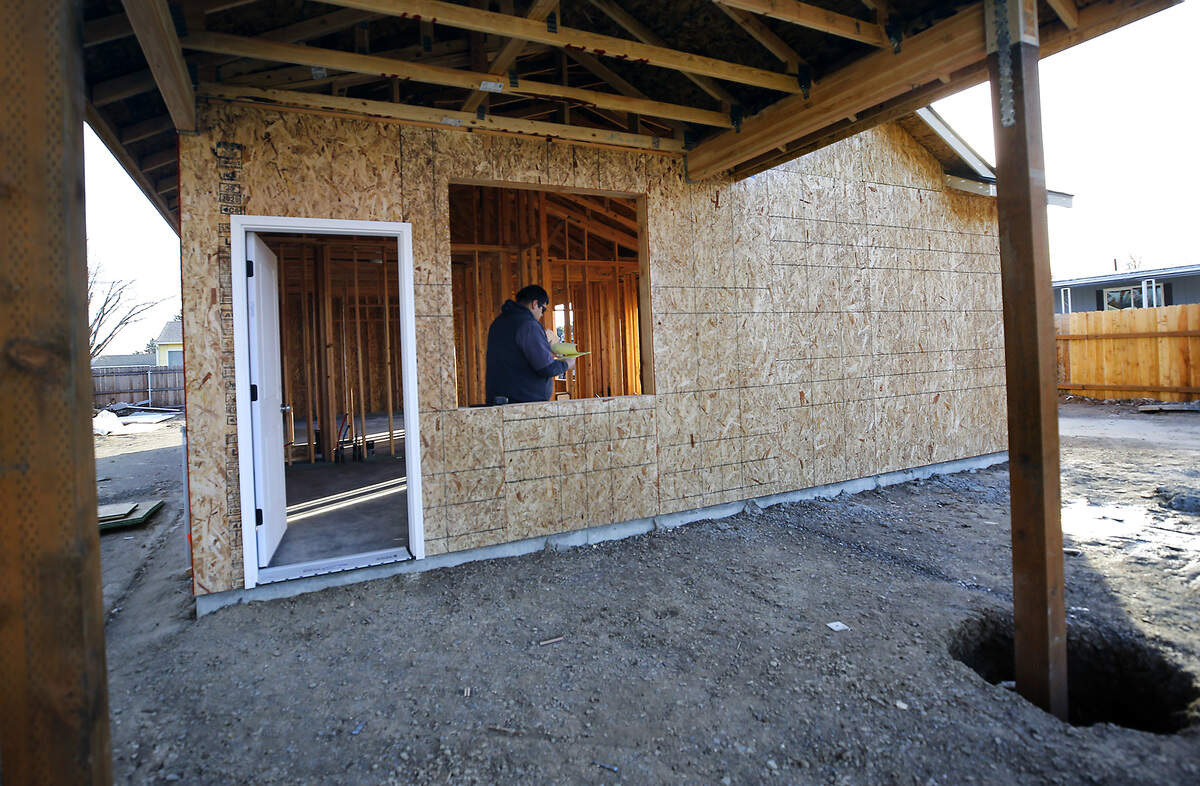 Jose Gutierrez, an employee of Z Plumberz & Soft Water Specialist, works on a material supply list at Jimmy Butcher's replacement home being constructed with donations and volunteer labor in Kennewick.