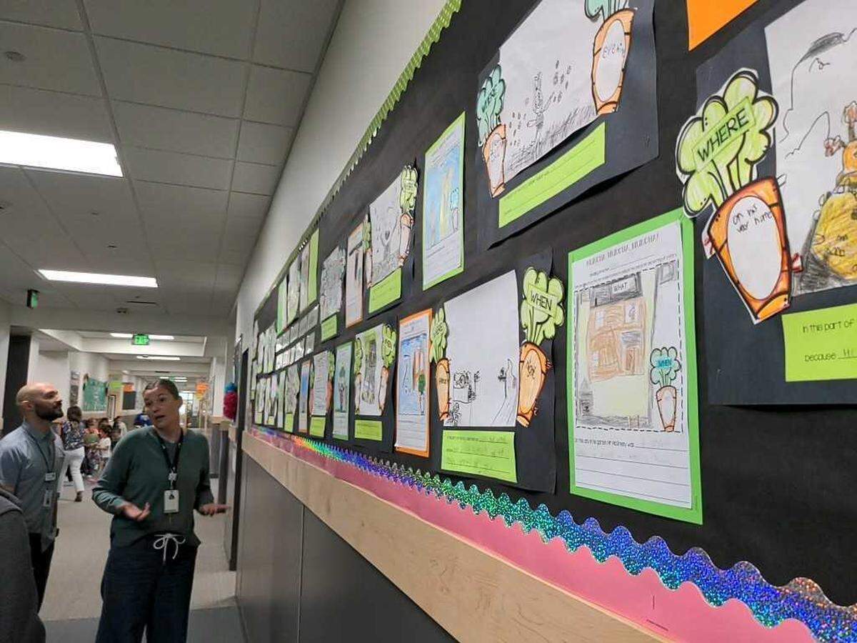 Three Rivers Elementary Principal Jamie Bacon, right, and Pasco School District support personnel Nick Castilleja look at 1st grade projects based on the book “Creepy Carrots” book.