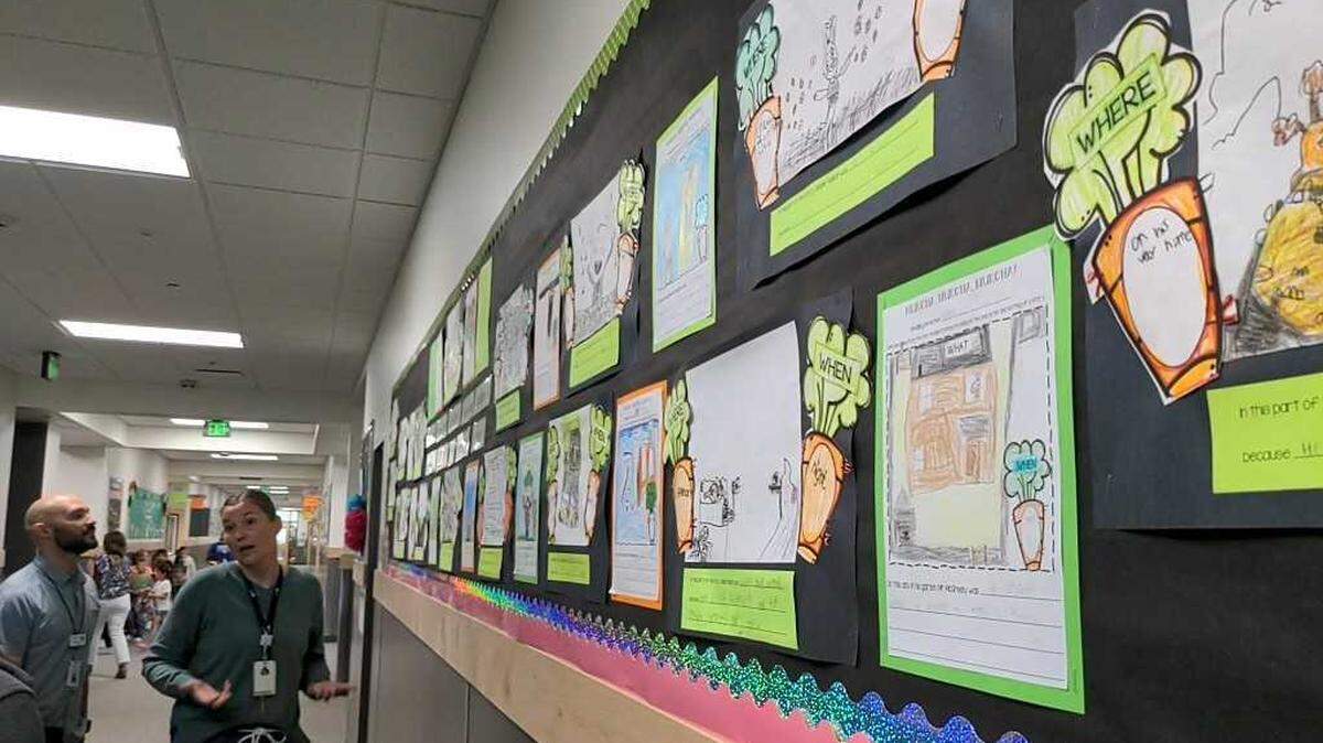 Three Rivers Elementary Principal Jamie Bacon, right, and Pasco School District support personnel Nick Castilleja look at 1st grade projects based on the book “Creepy Carrots” book.