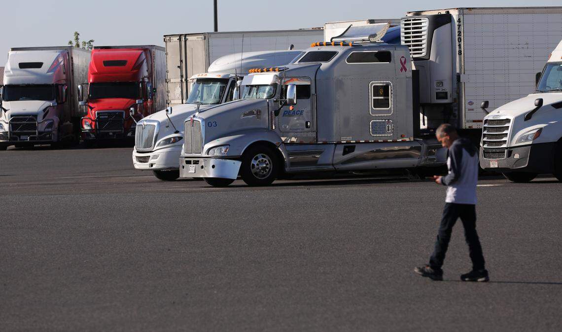 A driver walks past dozens of trucks parked in a popular truck stop and fueling station in the Kartchner interchange area in Pasco. Two developers are planning new truck stops to the same area in Pasco.