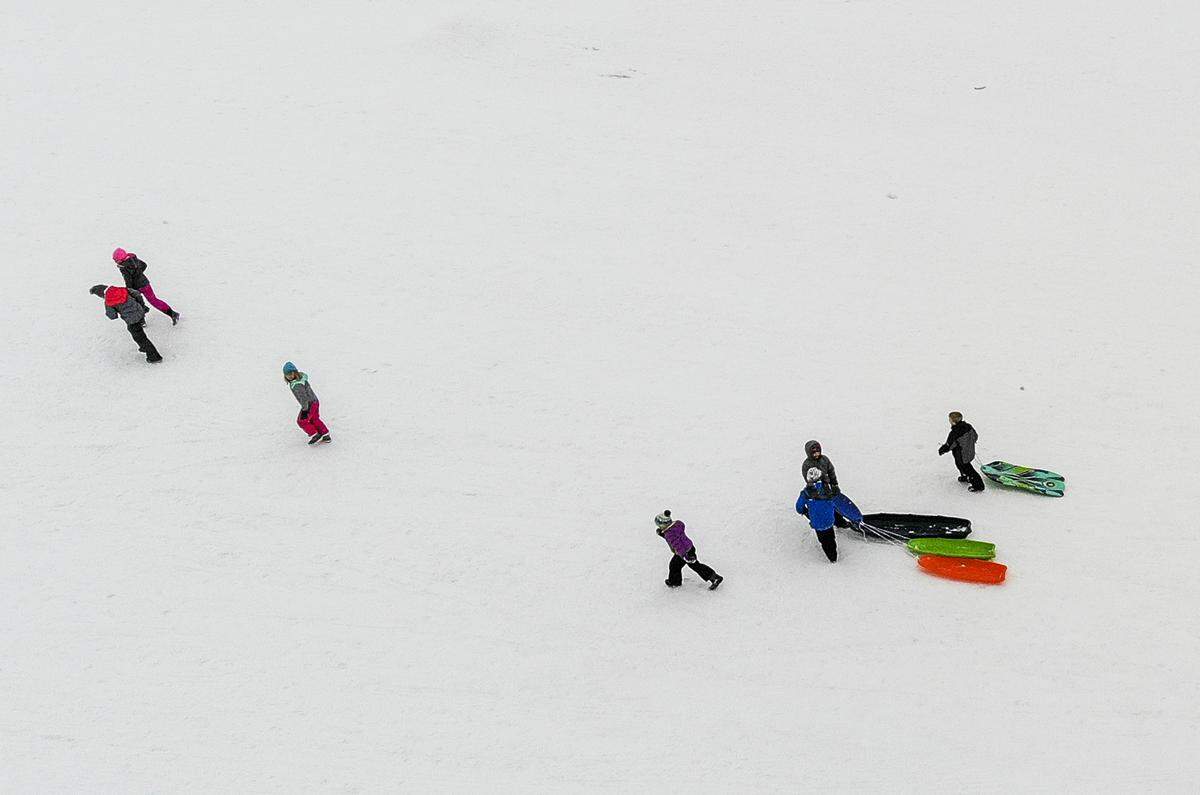 Kids trudge up a hill with their sleds at Carmichael Middle School in Richland on Tuesday. Classes were canceled because of the snow.