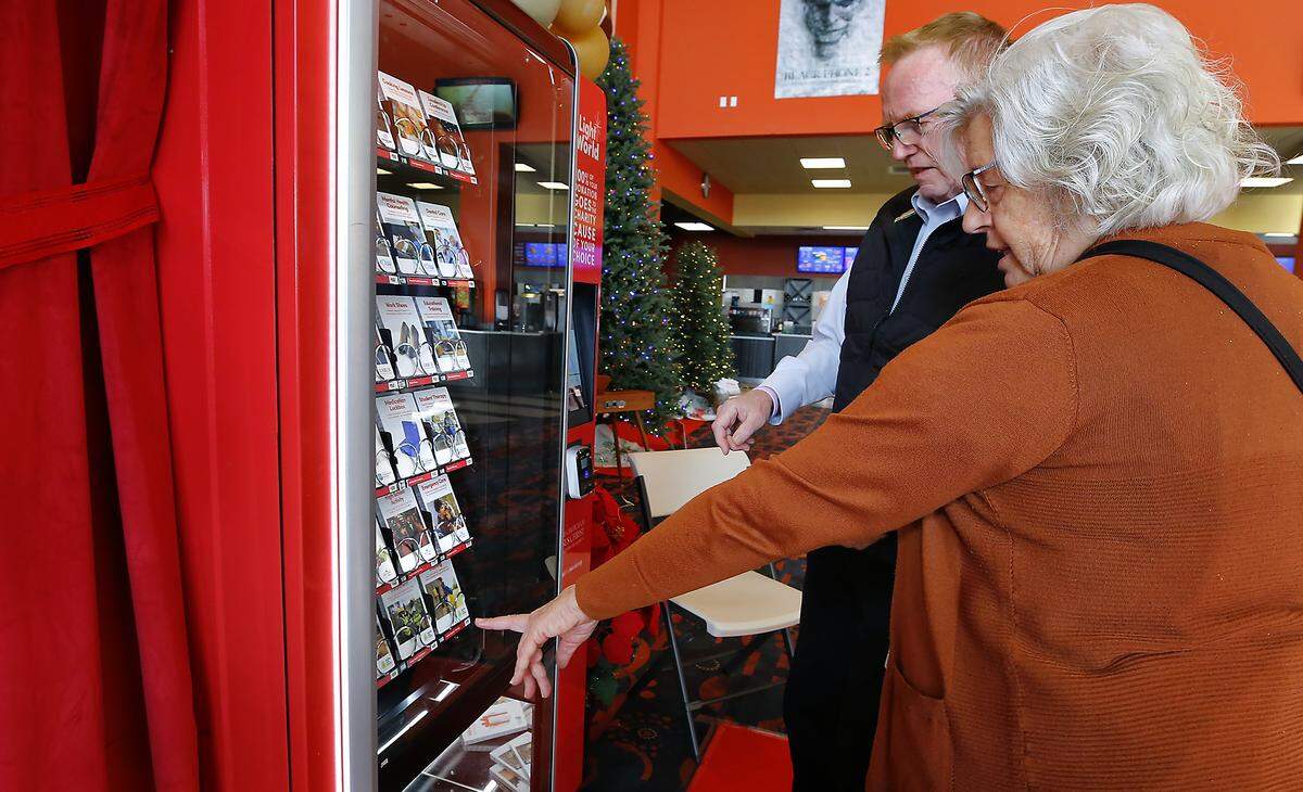 Janet and Dennis Scott of Richland prepare to buy their choices of gifts from of one of two Giving Machines stationed in the lobby of the Fairchild Cinemas Queensgate in Richland. 