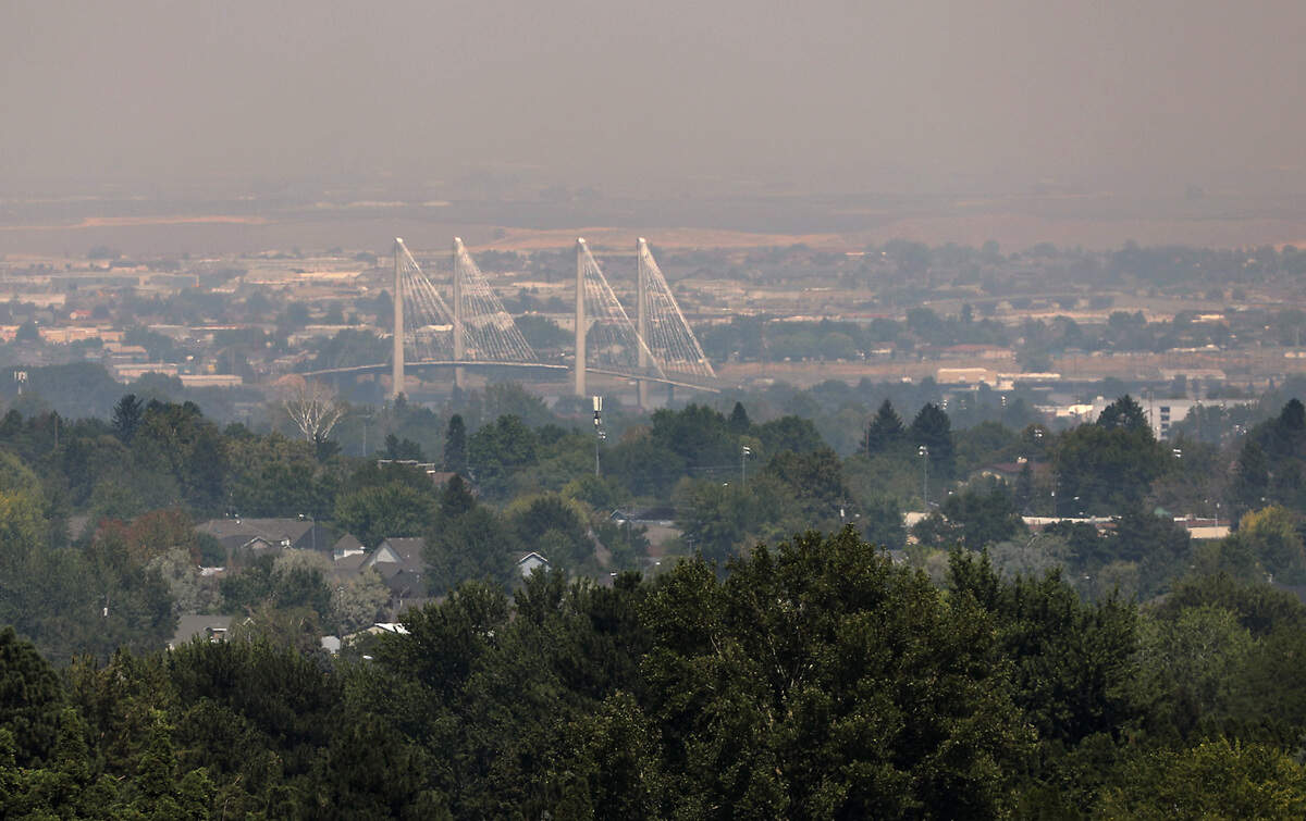 A smoky haze settles over the Tri-Cities Thursday afternoon obscuring the view of the cable bridge and the Pasco shoreline of the Columbia River while looking north from the south end of Ely Street in Kennewick.
