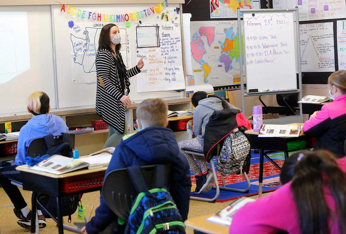 Fourth-grade teacher Leah Wright stands in a taped teaching area at the front of classroom as her students sit in spaced apart desks at McClintock STEM Elementary in Pasco.