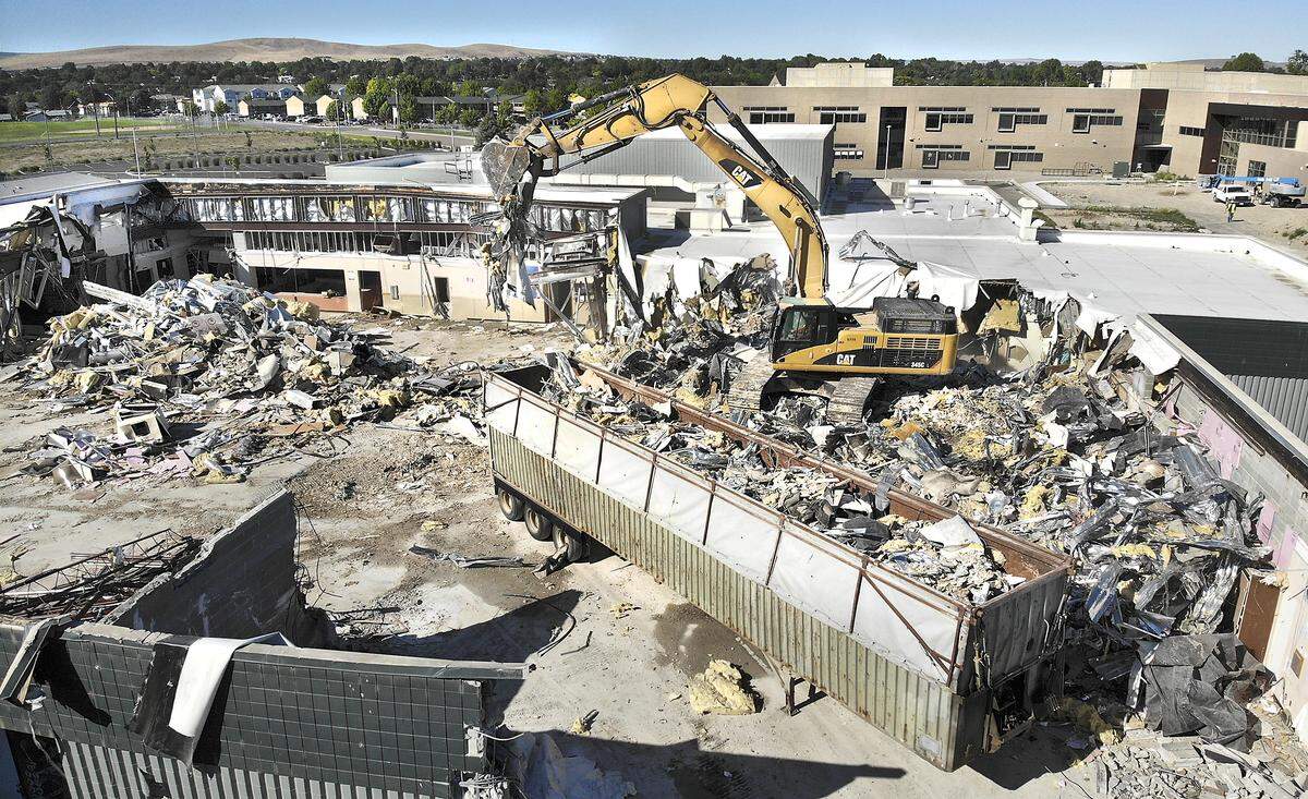 An excavator from Big D’s Construction fills a trailer with the debris from the demolition of the former Amistad Elementary School in Kennewick. The new 42-room school, built in two phases by Chervenell Construction, is to be completed in August. The $14.7 million project paid for with a local school bond and state school construction money is visible in the background. Watch a video at: tricityherald.com/videos.