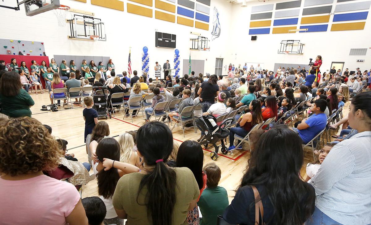 An overflow crowd fills the gymnasium and cafeteria area of the new Fuerza Elementary School in Kennewick on Thursday morning during the ribbon-cutting ceremony for the new dual-language facility. Watch a video at: tricityherald.com/video