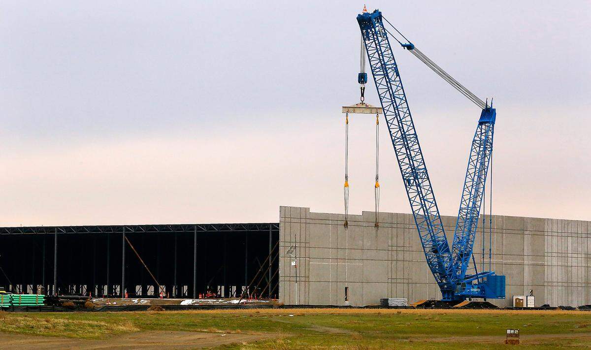 A crane is staged to lift walls into place for one of two new Amazon warehouses being constructed on North Road 40 East in Pasco.