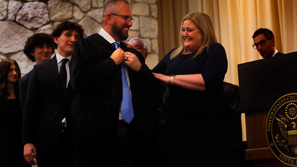 Judge Sal Mendoza is helped by his wife, Mia, during the robing ceremony Friday afternoon during his investiture to the United States Court of Appeals for the Ninth Circuit. Their children Carmaen, Anthony and Daniel joined the ceremony held at the Federal Building in Richland.