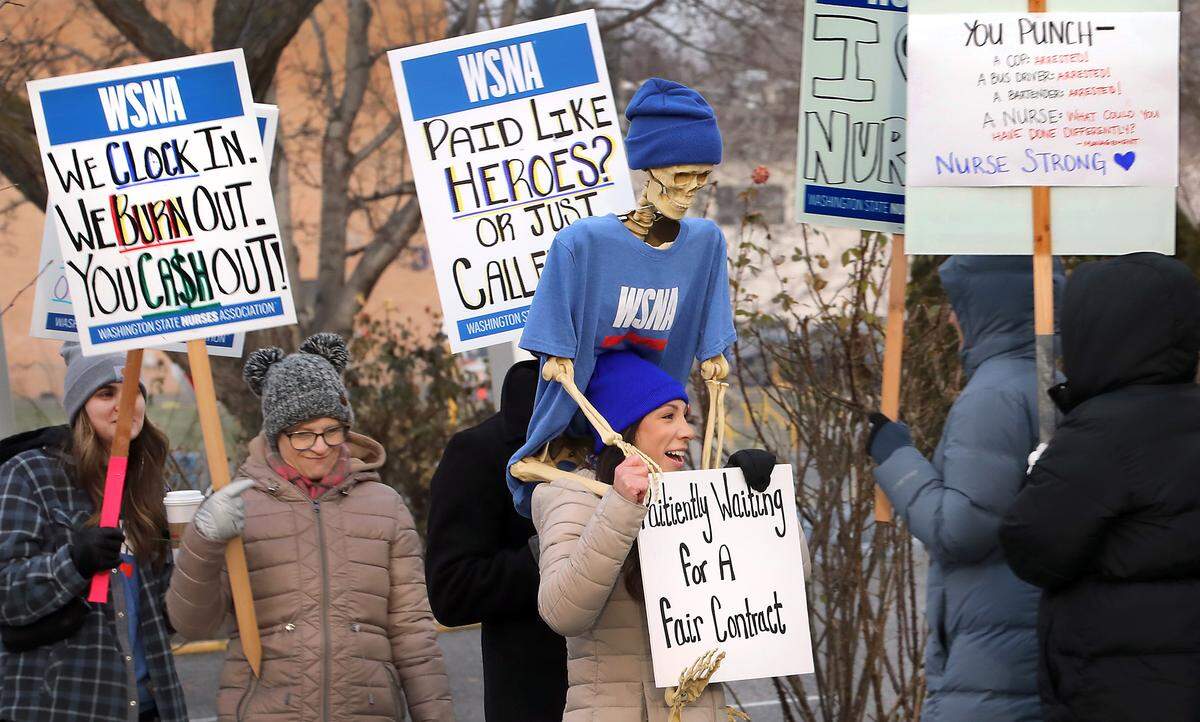Rachelle Hansen, a NICU nurse, carries a decorated plastic skeleton on her shoulders while walking with dozens of nurses who belong to the Washington State Nurses Association during an informational picket in front of Kadlec Regional Medical Center in Richland. Union representatives say the issues include: staffing levels, break relief, workplace safety and wages.