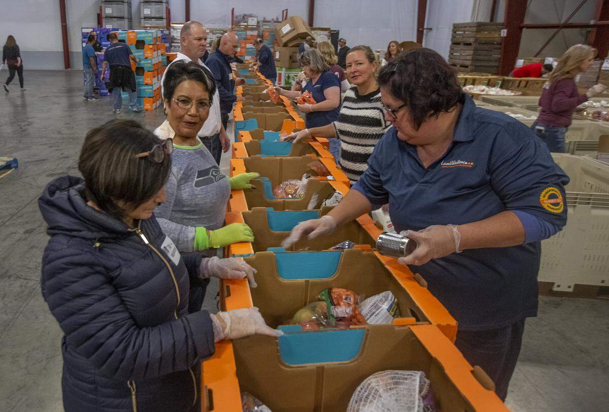 Volunteers fill holiday meal boxes with Thanksgiving food at Second Harvest distribution center in Pasco in this file photo.