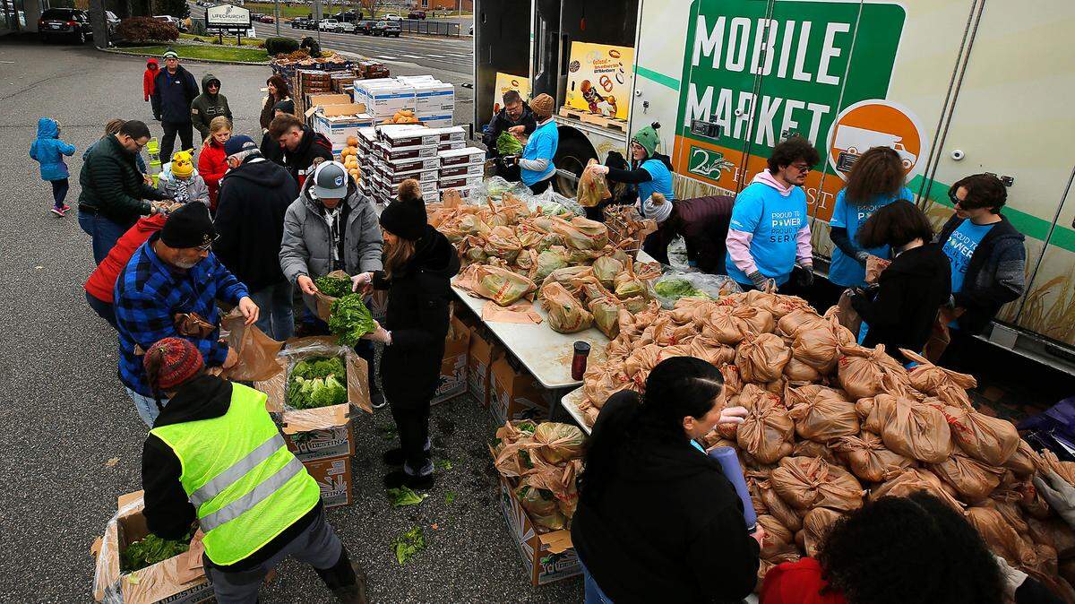 A small army of volunteers from LifeChurch7 and Energy Northwest work together Friday sorting and bagging fresh produce being distributed at the 2nd Harvest Mobile Market event in the parking lot of the LifeChurch7 in Richland.
