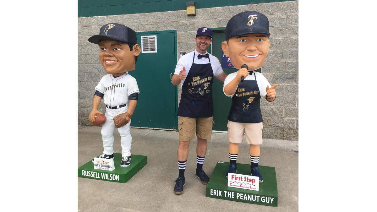 Erik Mertens, also known as Erik The Peanut Guy, stands next to the gigantic bobblehead of himself that the Tri-City Dust Devils had made in his honor.