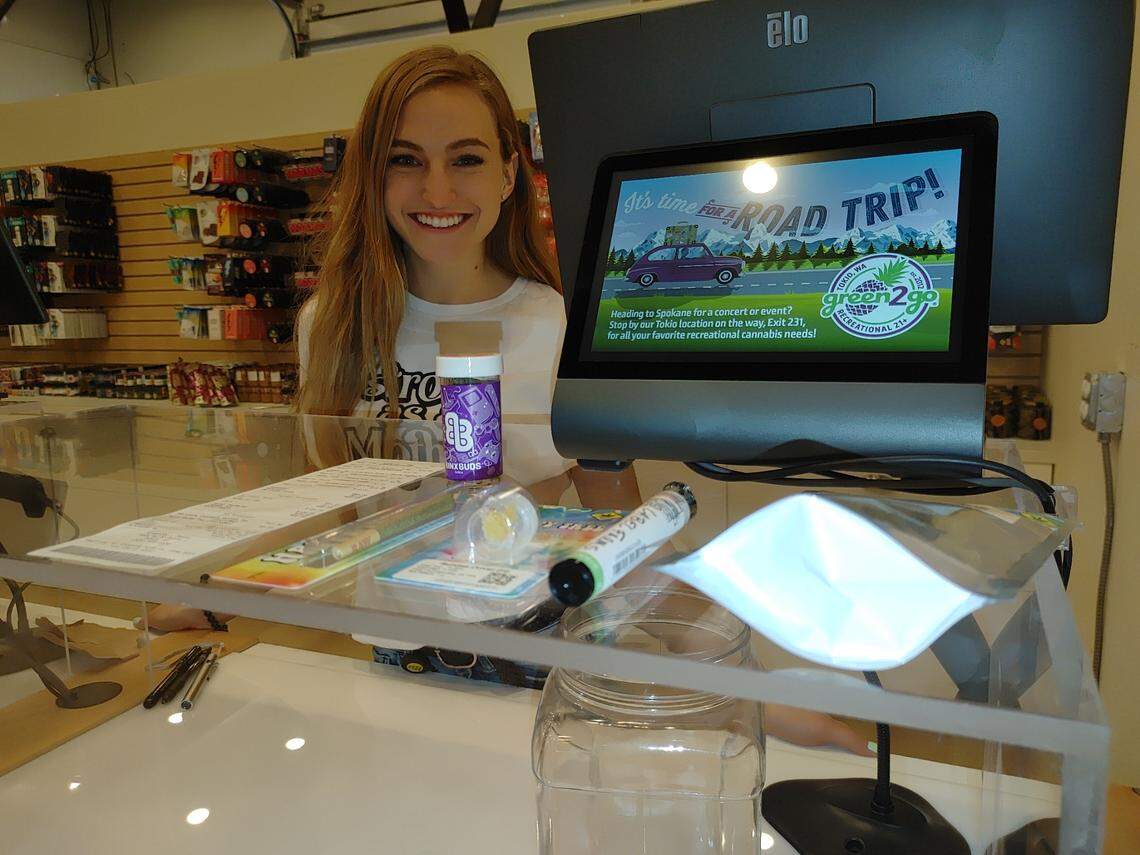 Naomi Wilcox of Green2Go Recreational shows the first legal cannabis sale in Pasco, to owner Steve Lee, on Nov. 2 shortly after the state finalized a business license for both it and for Lucky Leaf.