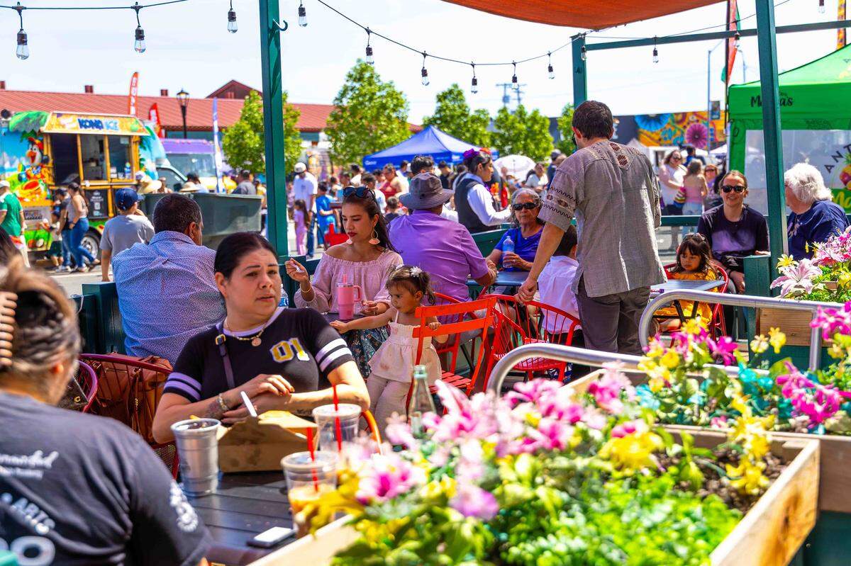 Families gather in shaded outdoor seating areas along South Fourth Avenue during Pasco’s Cinco de Mayo celebration on Saturday in downtown Pasco. 