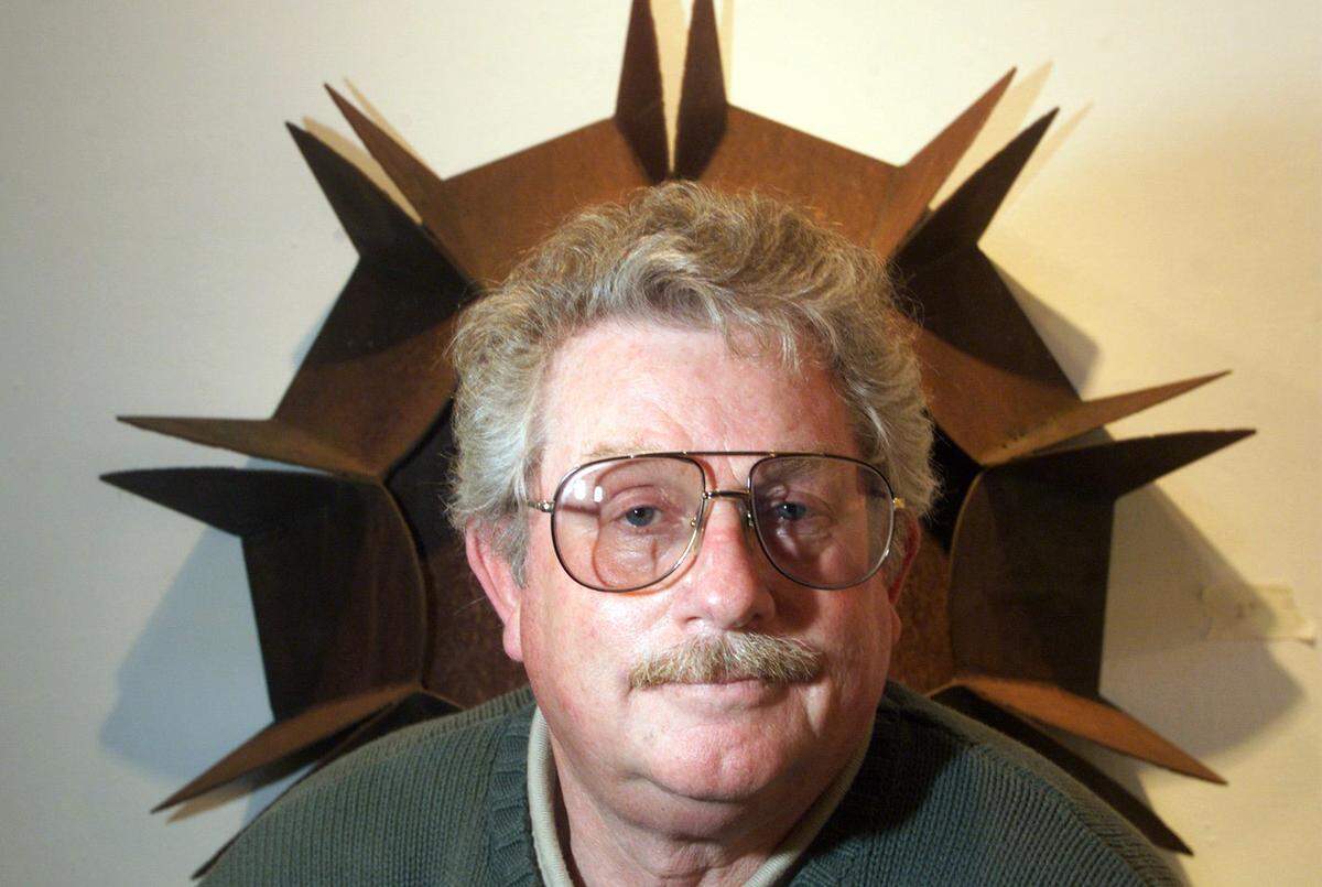 Ted Neth stands in front of his 1977 Cor-Tex steel piece titled Columbia Sun Burst at the Columbia Basin College gallery in Pasco.