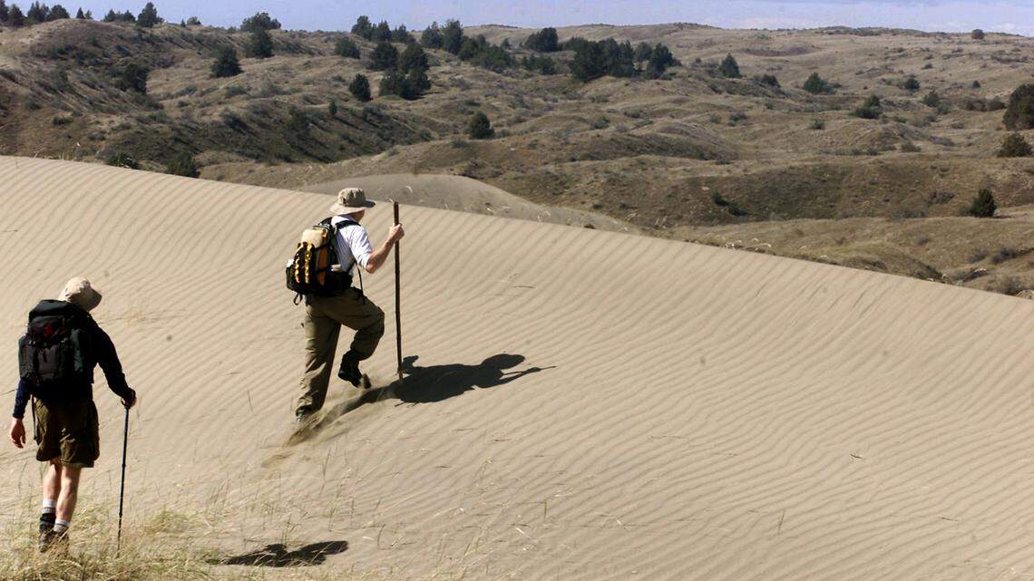 Hikers climb a sand dune at The Juniper Dunes Wilderness Area in Franklin County. Congress is set to vote on a bill to sell some Bureau of Land Management land in Washington, including some areas near the dunes.