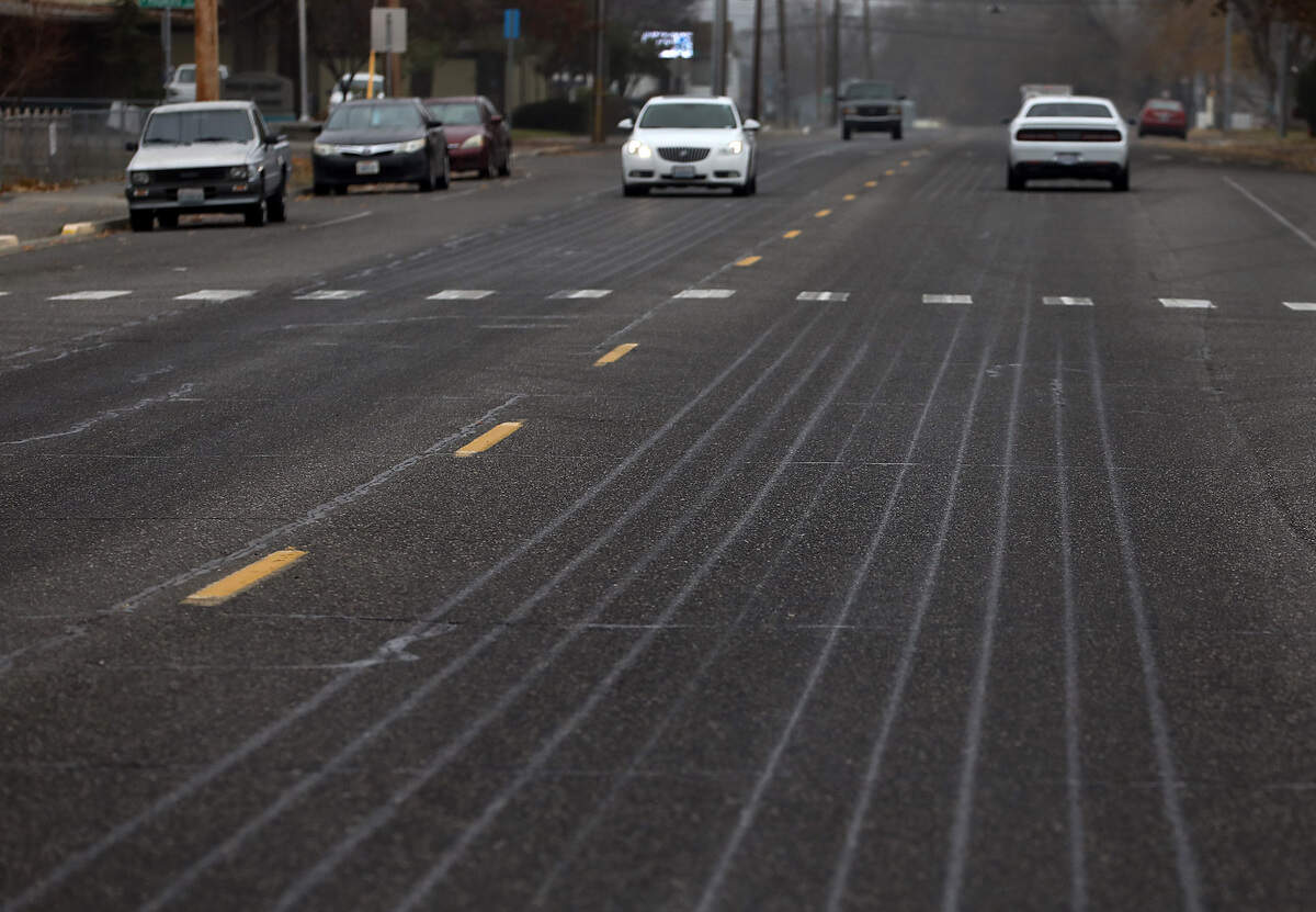 The lines from a fresh application of liquid de-icing solution are evident on the pavement of North 14th Avenue near the intersection with West Shoshone Street Wednesday morning in Pasco. The city operated spray truck was applying the solution following the National Weather Service forecast for up to a 50% chance of snow for the Tri-Cities area, with the best chance Thursday evening.