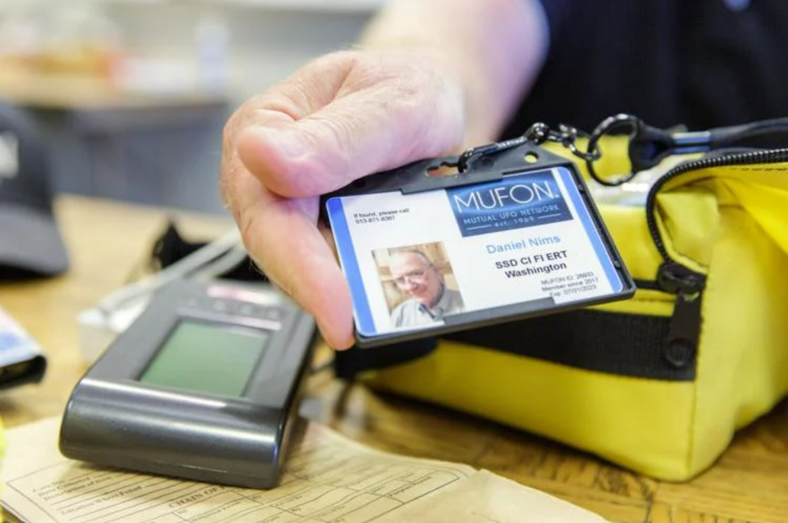 Dan Nims, Walla Walla, holds his Mutional UFO Network identification badge next to his electromagnetic spectrum detector.