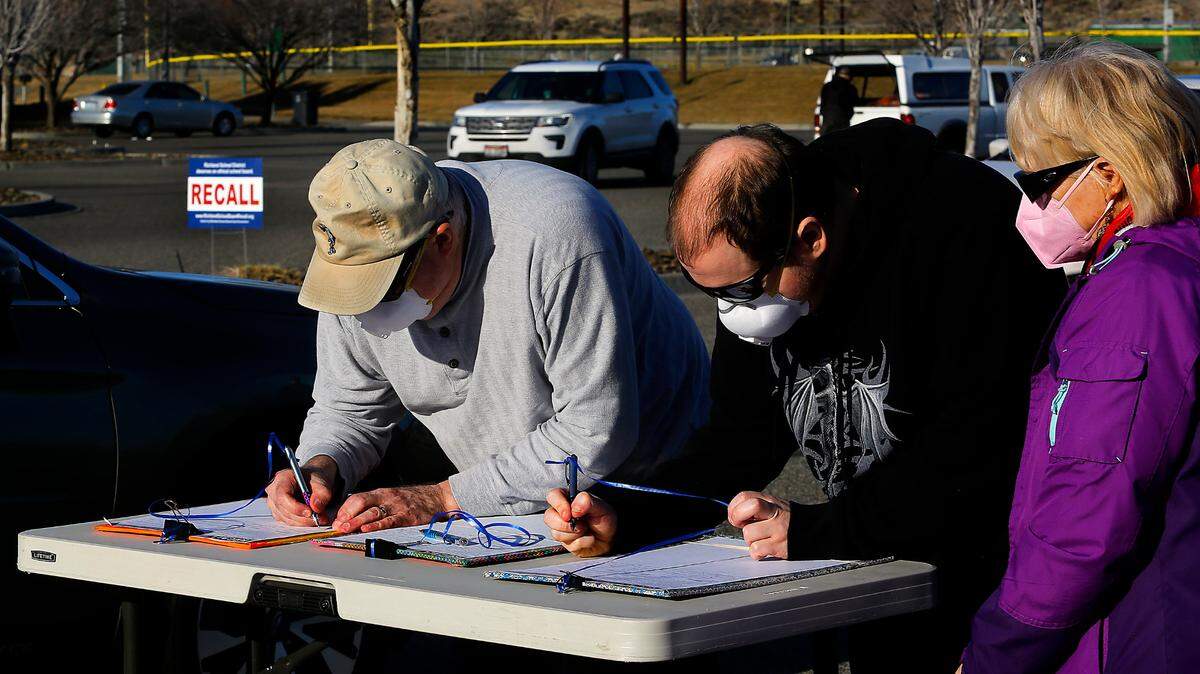 Richland School District residents line up at Badger Mountain Community Park in south Richland to sign three separate petitions for the recall of three Richland School Board members on the first day of collecting signatures after the Washington State Supreme Court ruling allowing the recall drive to move forward.