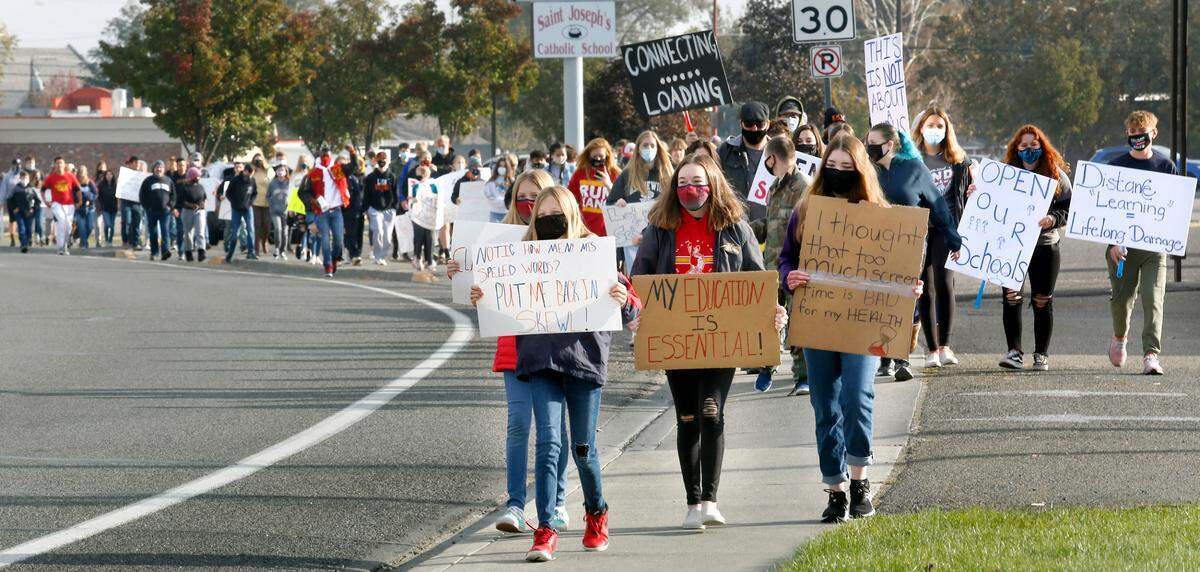 Several hundred students march along West Fourth Avenue to the Kennewick School District administrative offices Wednesday morning calling for the return of in-person learning following a recent decision by the school board to delay opening middle and high schools until Feb. 2. Watch a video at: tricityherald.com/videos