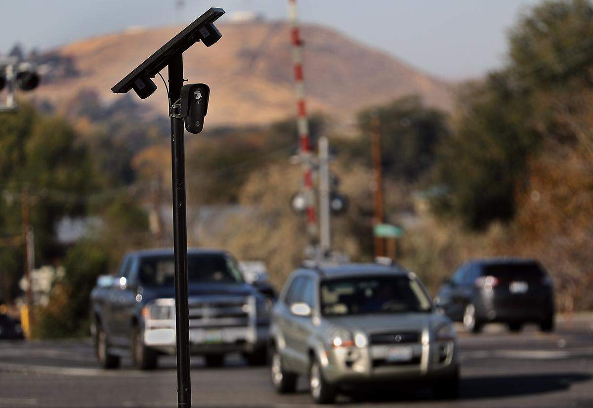 Traffic streams past a solar-powered license plate reading camera attached to metal pole on at the West Van Giesen Street and Highway 240 intersection in Richland