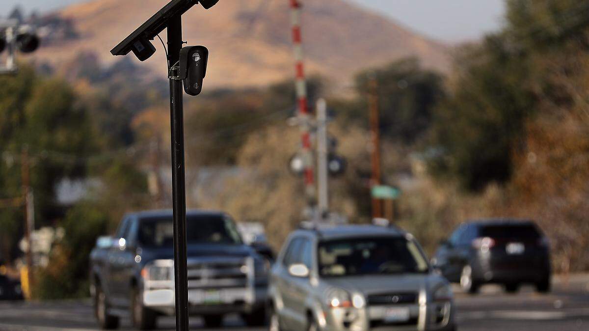 Traffic streams past a solar powered license plate reading camera attached to metal pole on at the West Van Giesen Street and Highway 240 intersection in Richland